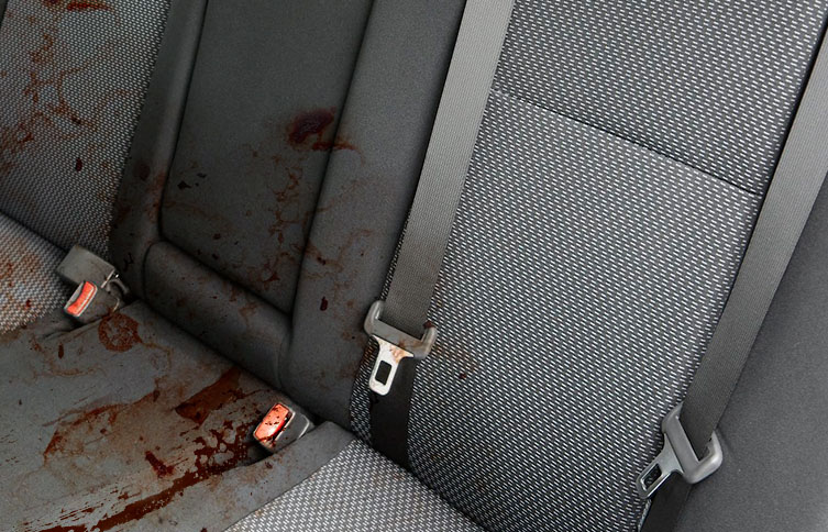 Blood stains on a car seat, requiring decontamination.