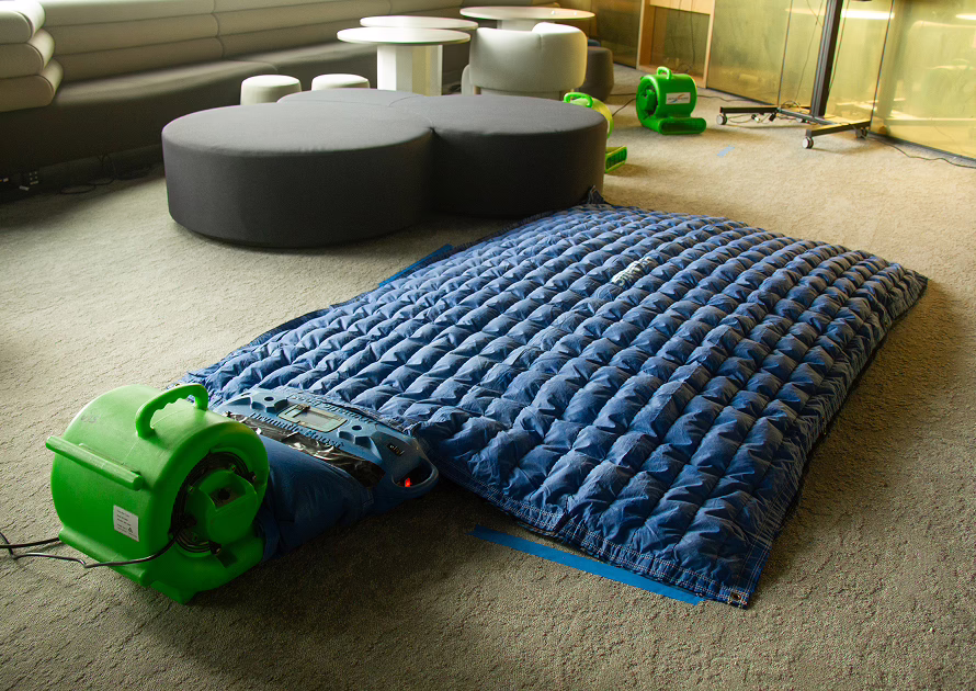 Air mover drying water damaged floor boards